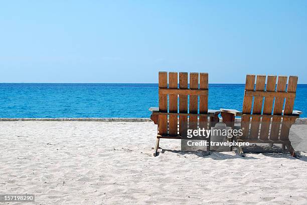 liegestühle am weißen sandstrand mit blick auf die karibik - aruba beach stock-fotos und bilder