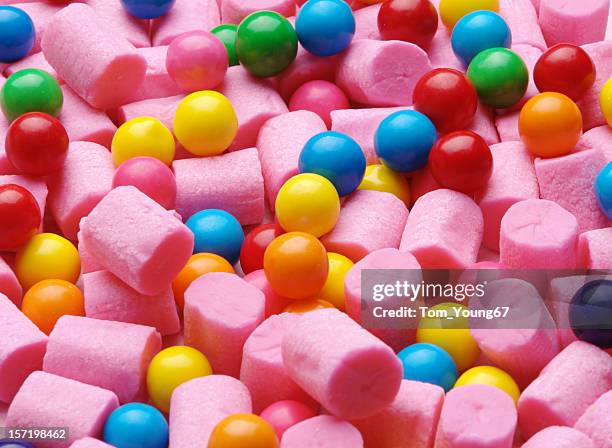 background of pink cylinder shaped gum and colorful gumballs - bubble gum stock pictures, royalty-free photos & images