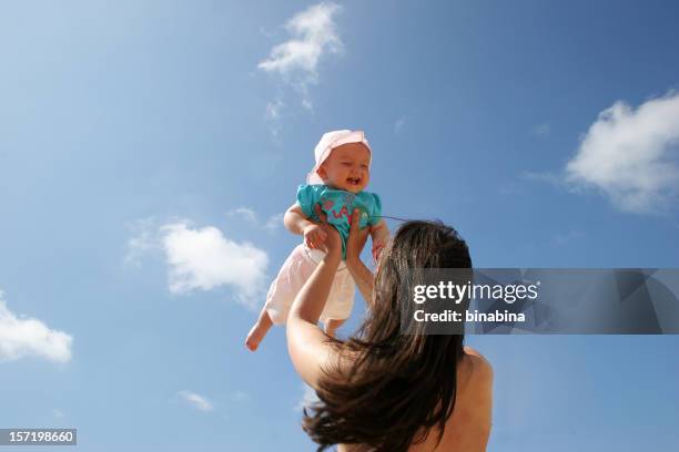 mother playing with baby in the sky - in de lucht zwevend stockfoto's en -beelden