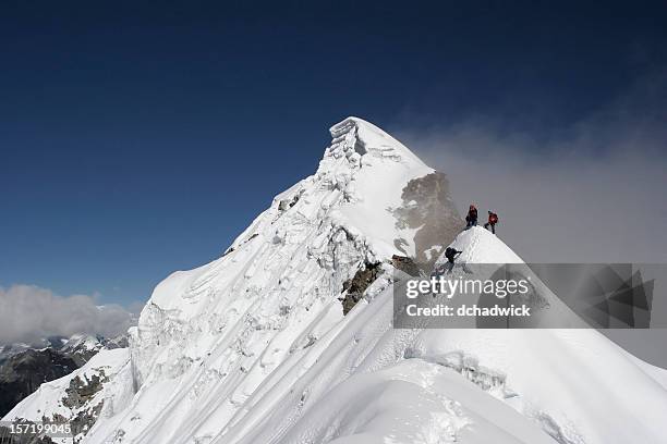 two climbers almost at the top of a snowy mountain top - upper 個照片及圖片檔