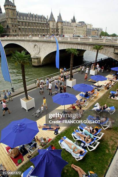 Des personnes se promènent et se reposent sur les berges de la Seine, le 20 juillet 2003 à Paris, le premier jour de l'opération "Paris Plage"...