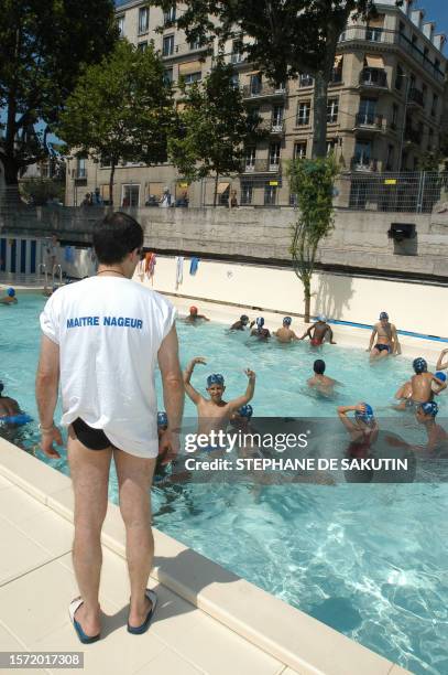 Des enfants se baignent sous la surveillance d'un maître-nageur dans le bassin de baignade aménagé le long des quais de la Seine dans le cadre de la...