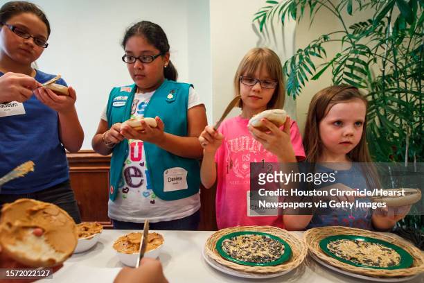 Madelyn Flores left to right, Daniela Alvarez Charlotte Fowler and Celeste Fowler make bird feeders using a bagel, birdseed, peanut butter and string...