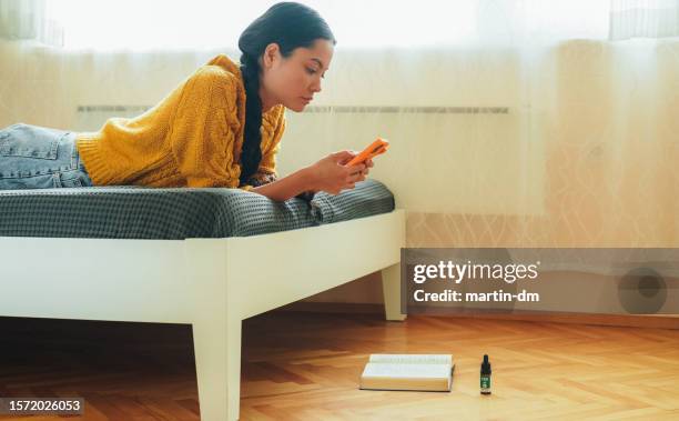 millennial at home using cbd oil for anxiety before an exam - ghosted stock pictures, royalty-free photos & images