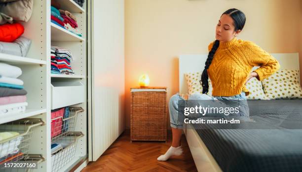 woman with backache staying at home - back pain bed stock pictures, royalty-free photos & images