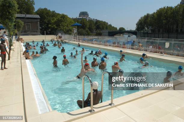Des enfants se baignent dans le bassin de baignade aménagé le long des quais de la Seine dans le cadre de la 3e édition de l'opération Paris-plage,...