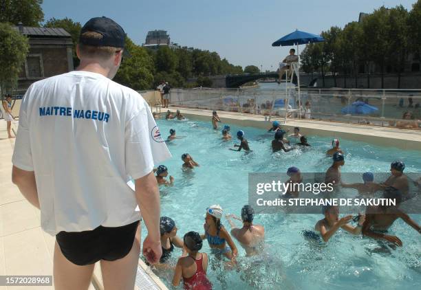 Des enfants se baignent sous la surveillance d'un maître-nageur dans le bassin de baignade aménagé le long des quais de la Seine dans le cadre de la...