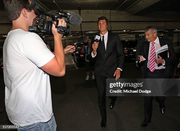 Adelaide Crows footballer Kurt Tippett walks out with David Galbally QC and picks up off the ground an AFL media microphone after the Adelaide Crows...