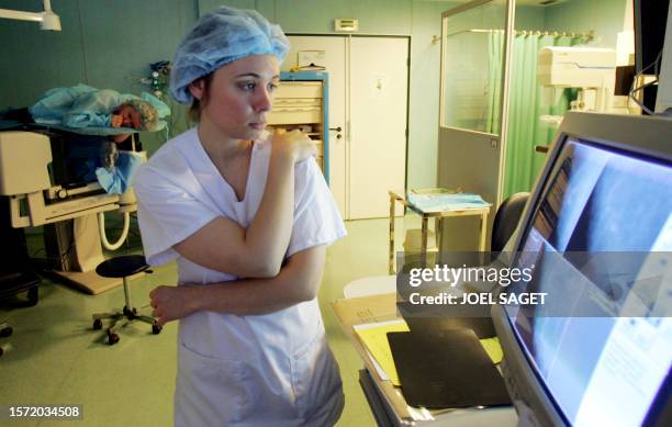 Une infirmière regarde des images faites lors d'une macrobiopsie par mammotome sur une patiente ayant présenté des lésions lors d'une mammographie le...