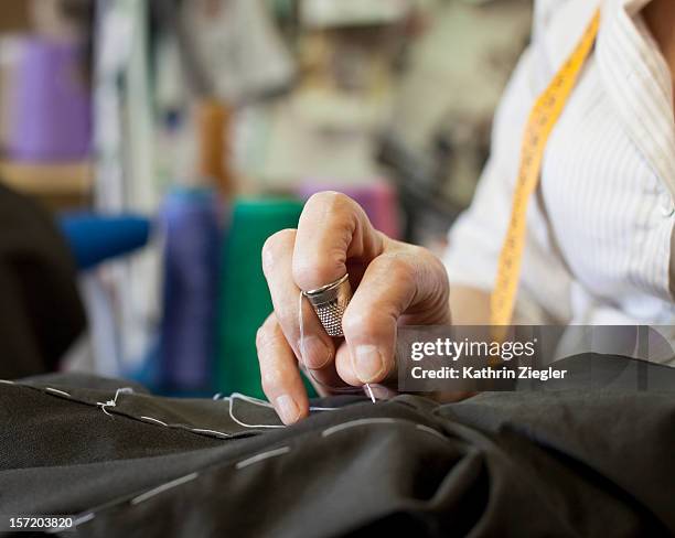 senior fashion designer sewing, close-up of hands - mani fili foto e immagini stock