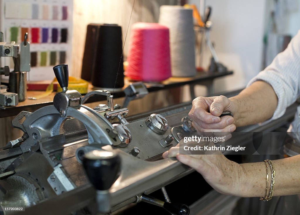 Senior fashion designer using knitting machine