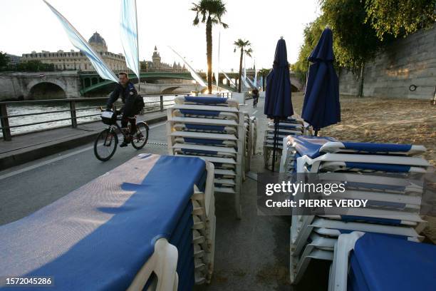 Des membres de la sécurité s'assurent que le public a quitté les quais de Seine lors de la fermeture de la cinquième édition de Paris-plage, le 20...