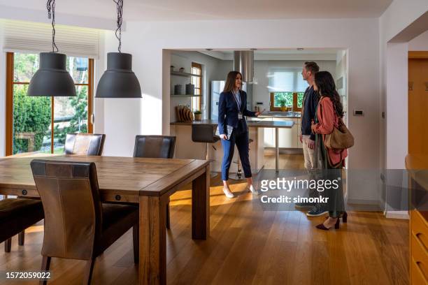 estate agent talking with couple - fato castanho imagens e fotografias de stock