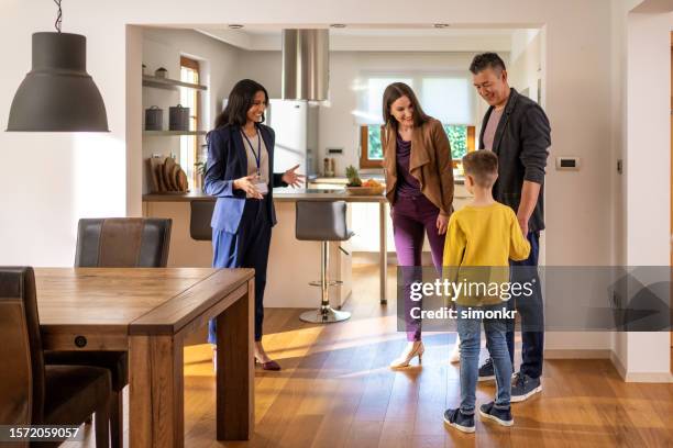 agente inmobiliario hablando con la familia - visita de inmuebles en venta fotografías e imágenes de stock