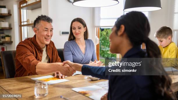 couple handshake with financial advisor - financial advisor with family stock pictures, royalty-free photos & images