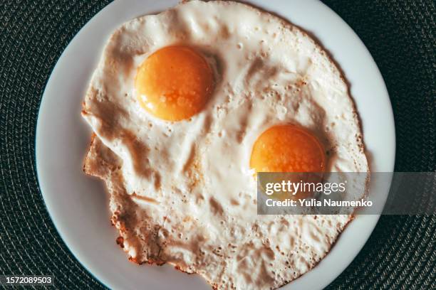 two fried eggs on a plate. protein breakfast. - sunny side up stock pictures, royalty-free photos & images
