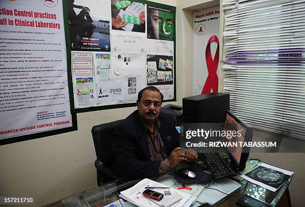 Health-AIDS-Pakistan-religion,FOCUS by Hasan Mansoor In this photograph taken on November 27 Munawar Khan, coordinator of Sindh province AIDS Control...