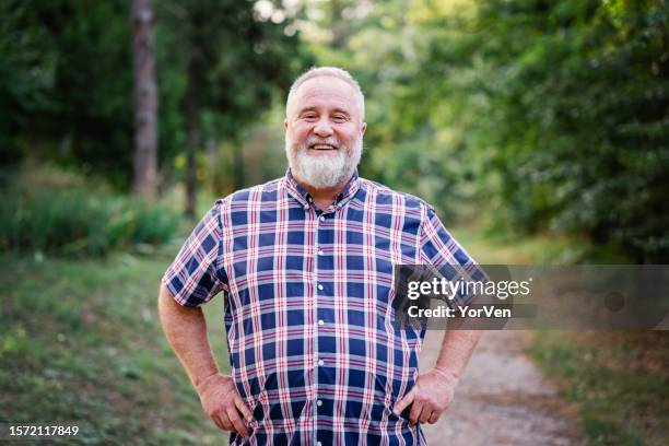 portrait of happy obese man walking in park - överviktig bildbanksfoton och bilder