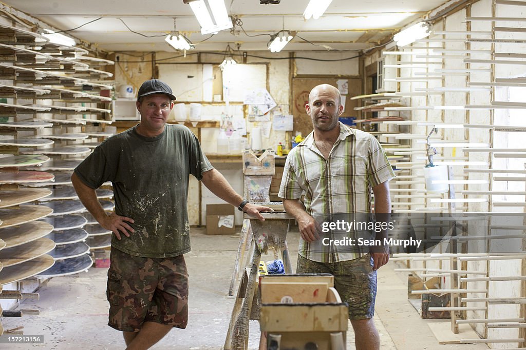 Two small shop owners standing inside a surf shop