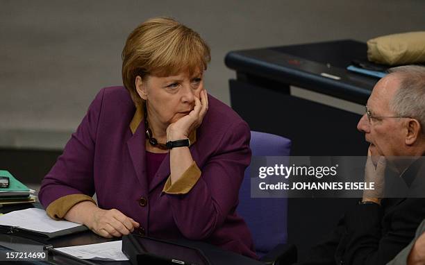 German Chancellor Angela Merkel talks with German Finance Minister Wolfgang Schaeuble during a session at the Bundestag on November 30, 2012 in...
