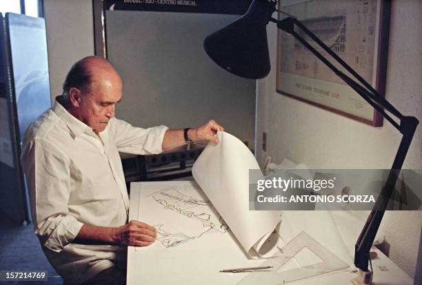 Brazilian architect Oscar Niemeyer looks at drawings for a project of two cities in Senegal, Africa, in his office in Rio de Janeiro, 23 January 1992.