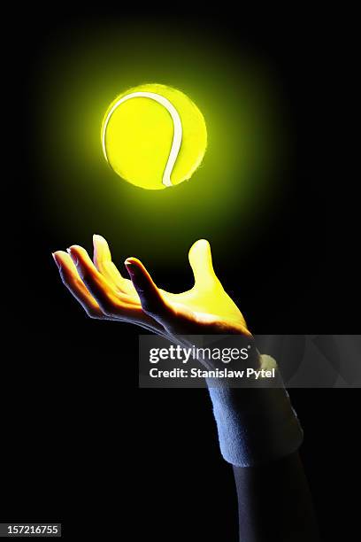 hand of tennis player holding glowing ball - tennis ball hand stock pictures, royalty-free photos & images