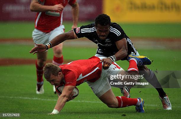 Will Thomas of Wales is tackled by Lote Raikabula of New Zealand during the pool B match in the Emirates Airline Dubai Rugby Sevens on November 30,...