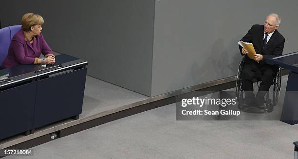 German Chancellor Angela Merkel looks on as Finance Minister Wolfgang Schaeuble leaves the podium after speaking during debates over a financial aid...