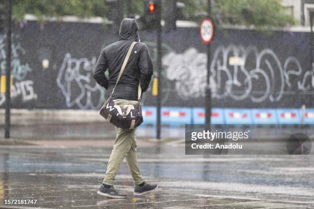 Man walks on the street during the heavy rain in London, United Kingdom on August 02, 2023. The UK's national weather service, the Met Office, said a...