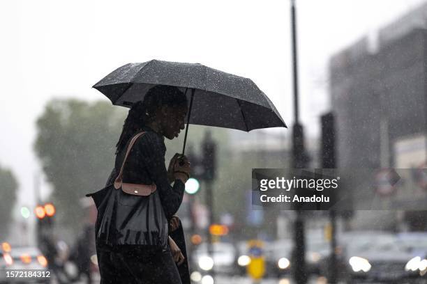 Woman walks on the street with an umbrella during the heavy rain in London, United Kingdom on August 02, 2023. The UK's national weather service, the...