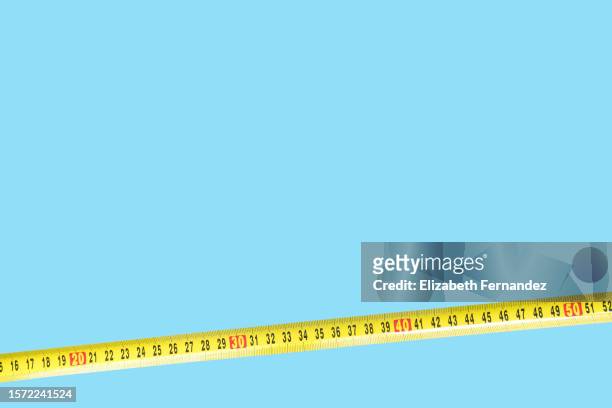 yellow tape measure on blue background - meter unit of length stock pictures, royalty-free photos & images