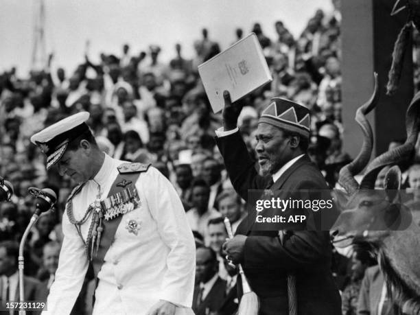 Mau Mau leader of Kenya African National Union , Jomo Kenyatta, holds the official document of Kenya independence, December 13, 1963 in Nairobi as he...