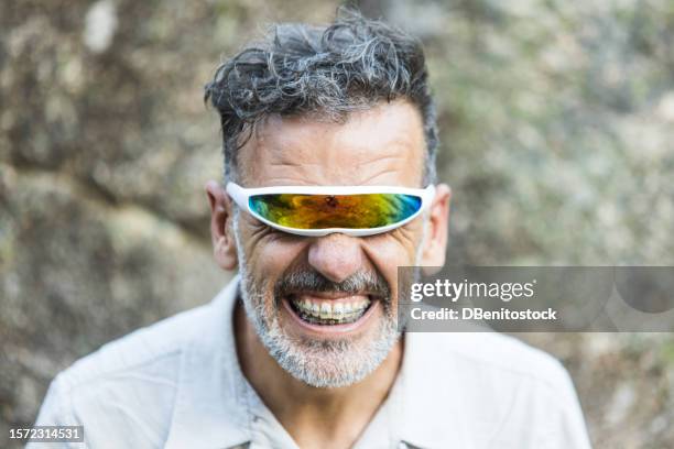 portrait of a mature man with braces wearing futuristic single-lens and mirrored glasses, opening his mouth. concept of dentist, orthodontics, irons, treatment, smile and ugly. - toothy smile stock-fotos und bilder