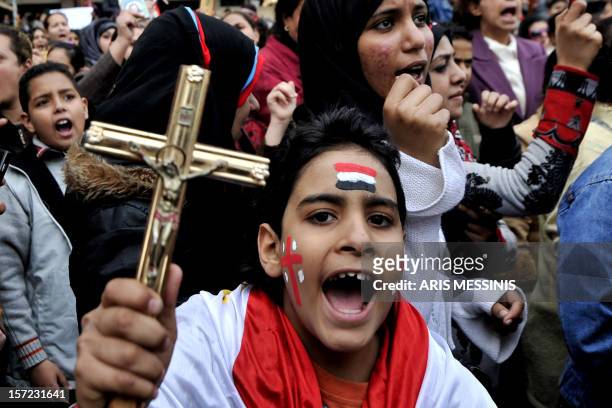An Egyptian Coptic Christian boy shouts slogans while holding a crucifix during a protest outside the Egyptian state television building in Cairo on...