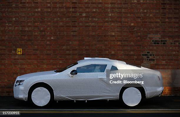 Protective cover sits on a completed Bentley Continental automobile parked outside the workshop at the Bentley Motors Ltd. Plant in Crewe, U.K., on...