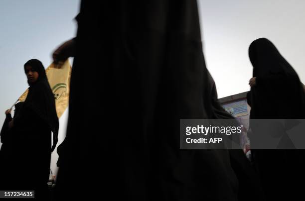 Bahraini Shiite Muslim women waving political flags take part in a march in the village of Karranah, West of Manama, on November 30 in solidarity...