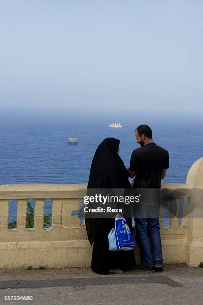 July 27th Algeria. How many love whispers are entrusted to the Mediterranean? A couple talks as they look out onto the sea.