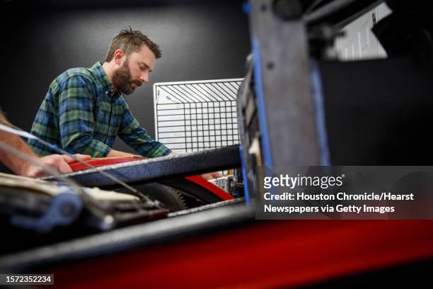 John Earles works to set up registration on a business card while using a 1897 Chandler and Price Old Style letterpress at Spindletop Design and...