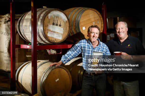 Java Pura coffee roasting partners Richard Colt, left, and Fielding Cocke stand in front of the wine and beer casks that are used to age their coffee...