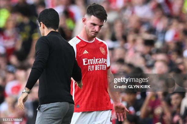 Arsenal's Spanish manager Mikel Arteta shakes hands with Arsenal's English midfielder Declan Rice as he leaves the pitch during the pre-season...