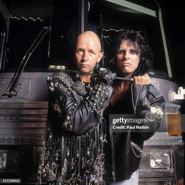 Heavy metal singers Rob Halford and Alice Cooper pose in front of a tourbus, early 1990s.