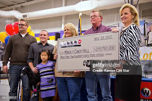 Cindy and Mark Hill, center and second from right, stand with a ceremonial check from the Missouri Lottery for $293 000 during the news conference,...