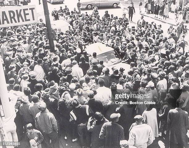 Dr. Martin Luther King, Jr. Speaks speaks to the crowd through a bullhorn while standing on a car on Blue Hill Avenue in Roxbury. Dr. King led a...