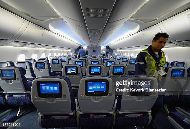 People walk through the United Airlines Economy Class with personal entertainment systems, with 13 languages available, on the new Boeing 787...