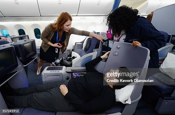 United Airlines employee Jennifer Dohm helps United sales manager Marilyn Jablonsky with the lighting as a flight attendant looks on while they tour...