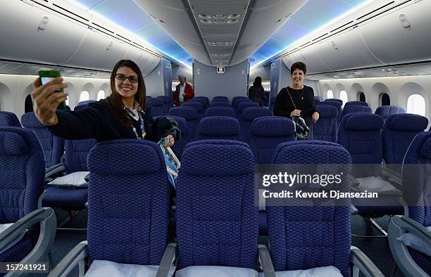United Airlines customer service representative Desiree Yoos takes a her picture inside the cabin while touring the new Boeing 787 Dreamliner at Los...