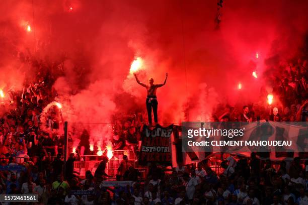 Marseille's supporters light flares prior to the pre-season friendly football match between Olympique Marseille and Bayer Leverkusen at the Stade...
