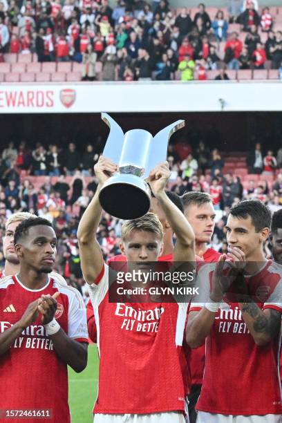 Arsenal's Norwegian midfielder Martin Odegaard lifts the trophy after winning the pre-season friendly football match for the Emirates Cup final...