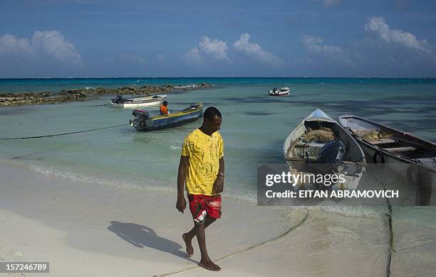 Man walks next to fishing boats in San Andres Island, Colombia, on November 30, 2012. Colombia on Wednesday said it would no longer recognize the...