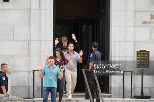 Staff members exit the Russell Senate Office Building with their hands raised over their heads on Capitol Hill in Washington, DC, US, on Wednesday,...
